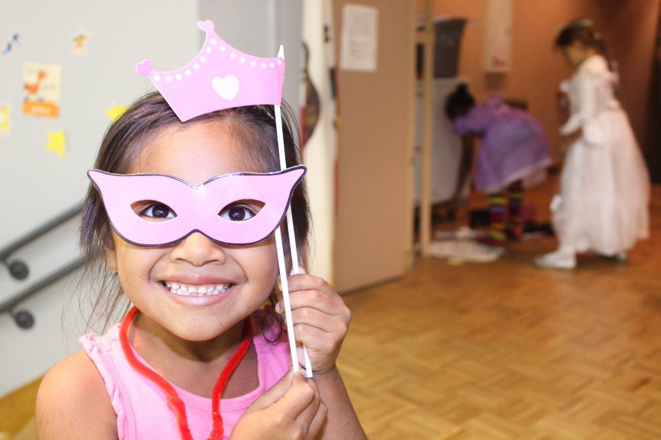 Student posing with a masquerade mask 