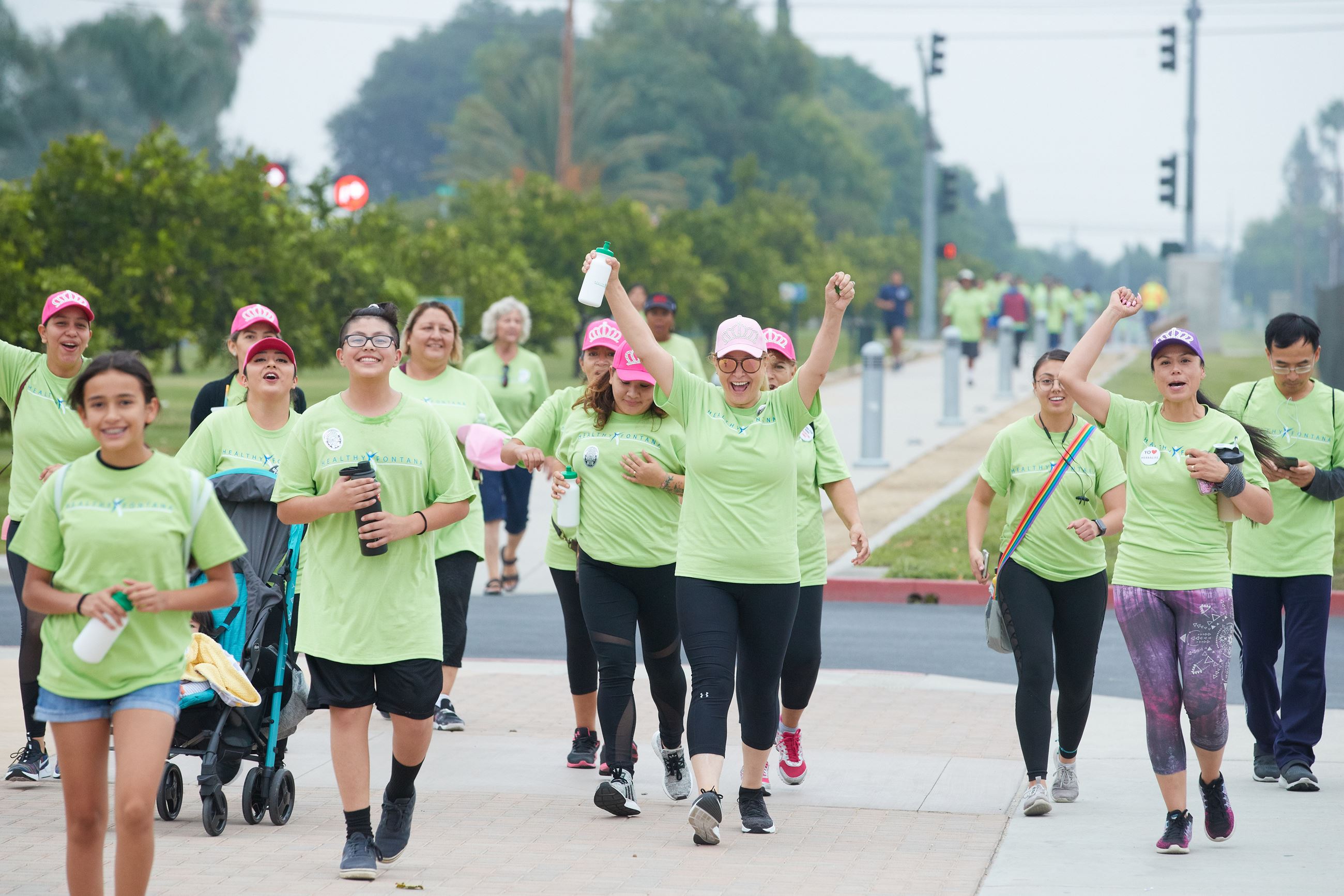 Large group of Fontana Walks participants walking and cheering.